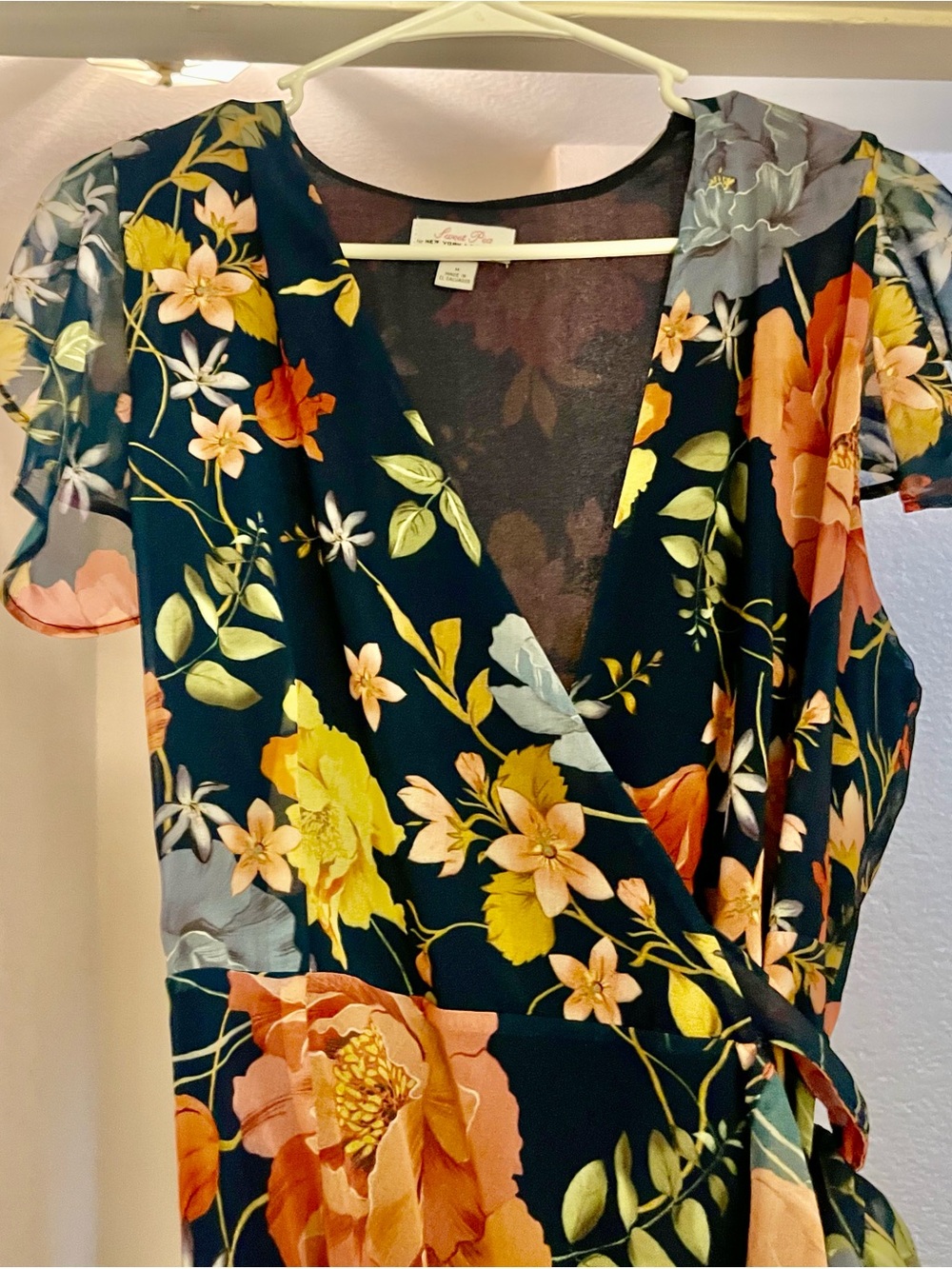 Sweet Pea Floral Wrap Dress with Multi Colored Blooms and Navy Blue Backdrop